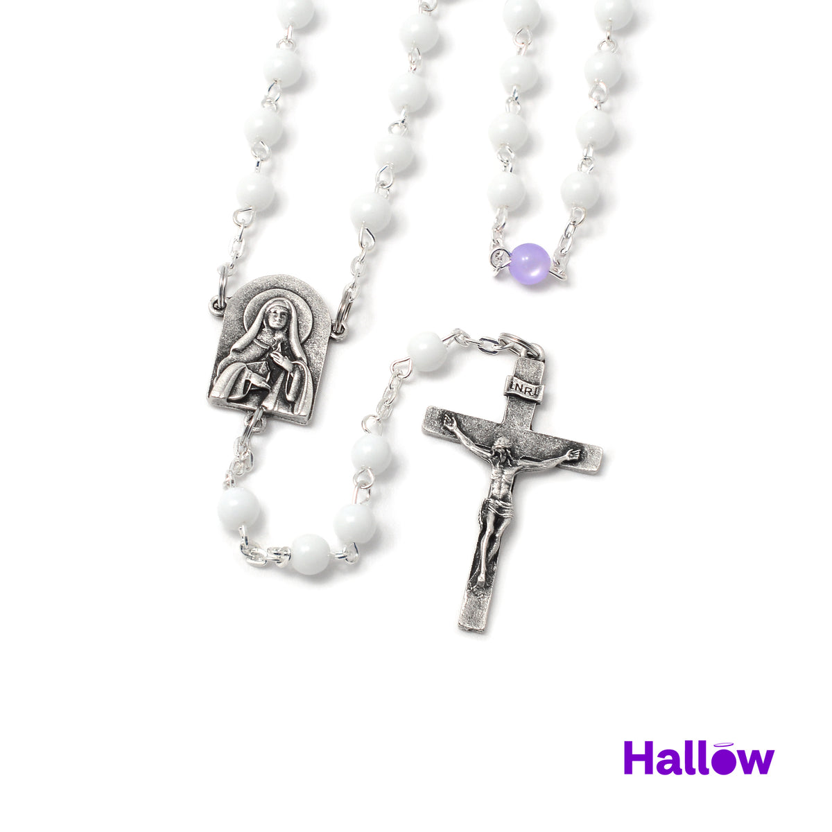 An image of a rosary featuring a silver cross and centerpiece, with white beads and purple accents, and the Hallow brand logo visible.