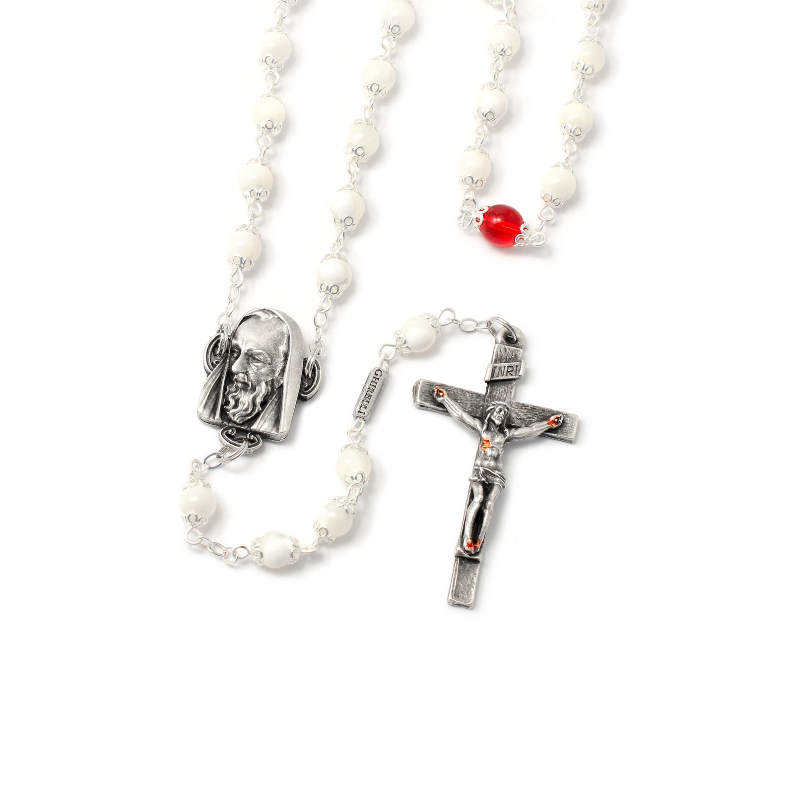 A rosary with antique silver caps on the beads, featuring a white crucifix with red details, and a center piece with a depiction of Saint Pio. Some beads are mother-of-pearl, and the rest are red.