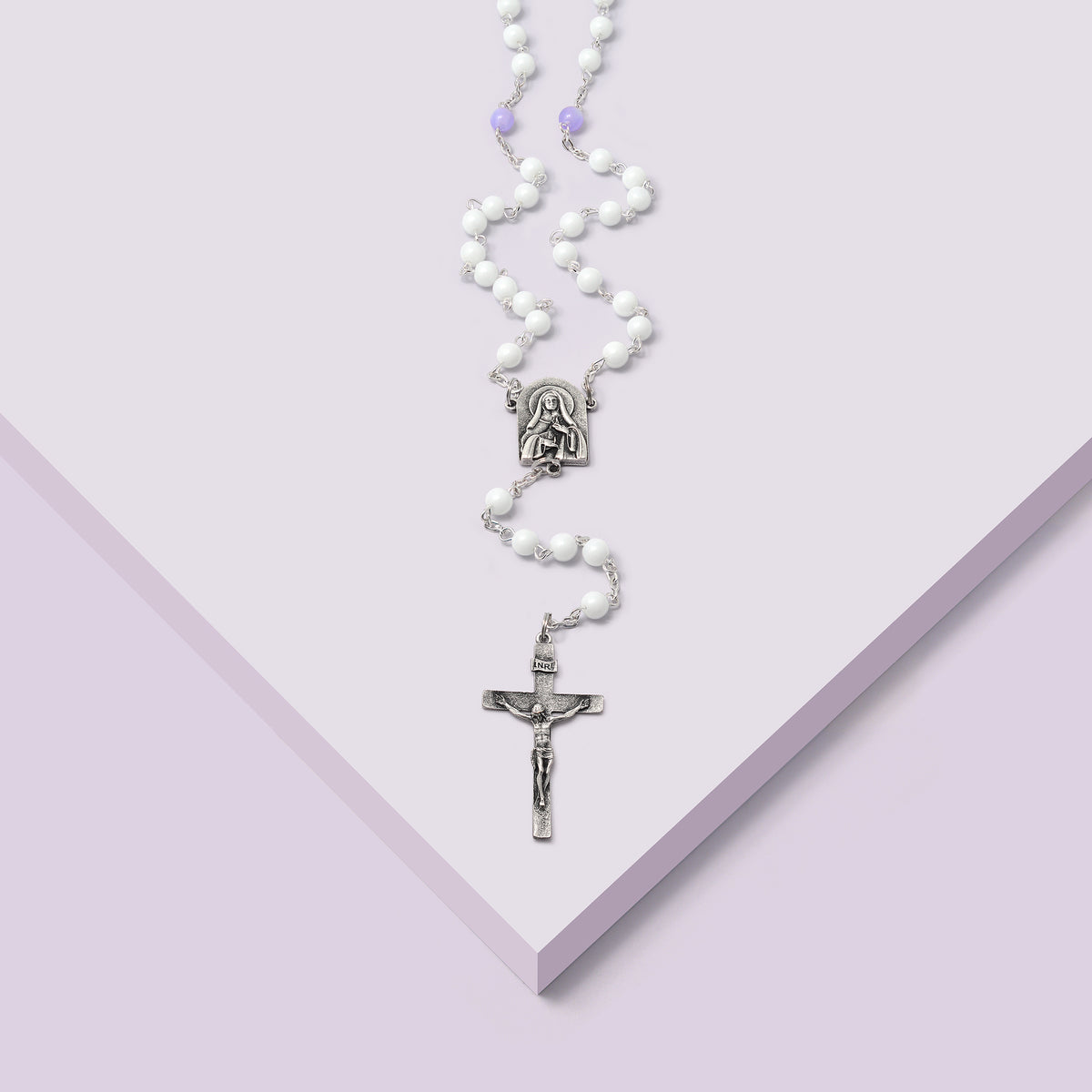 Close-up of the Hallow® rosary crucifix in antique silver finish, featuring Jesus in minimalist design.